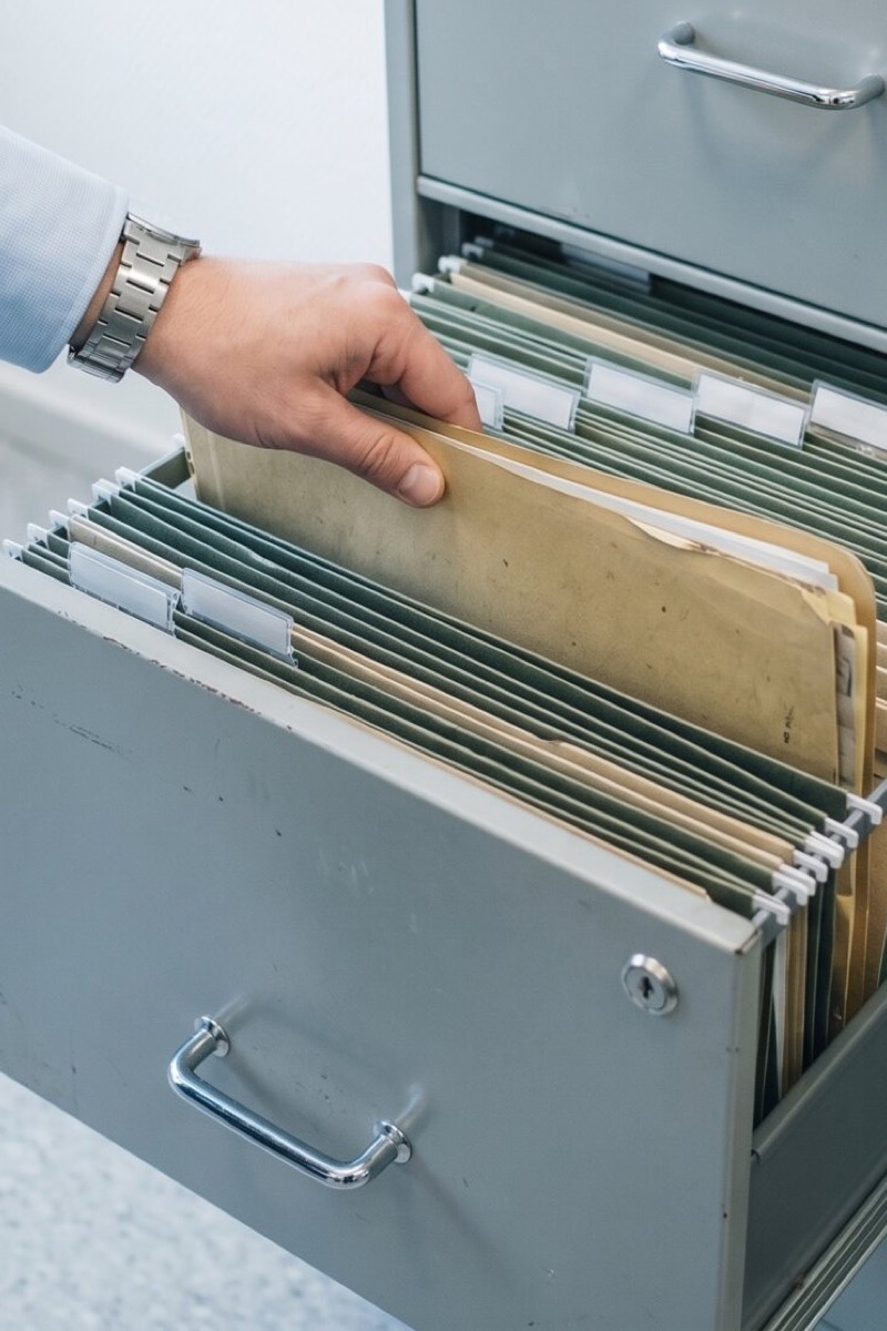 Hand zieht eine Personalakte aus dem Aktenschrank — konkretes Fehlverhalten datiert und nachvollziehbar dokumentiert